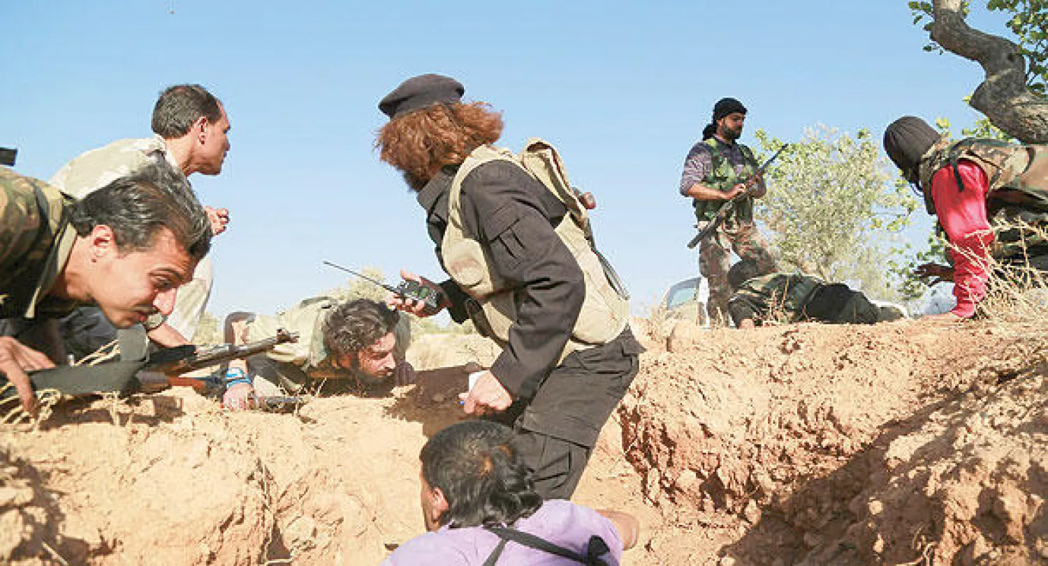 صورة وزعت أمس لمقاتلين من حركة حزم وهم يتموضعون بعد سقوط قذيفة هاون على مقربة منهم في حي شيخ سعد بحلب أمس (رويترز)