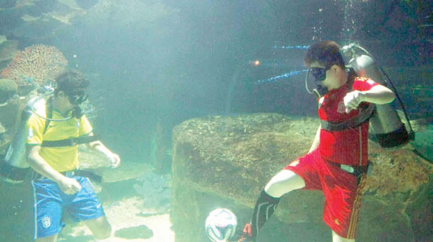 شبان يلعبون الكرة في قاع البحر خلال أحد المهرجانات الترويجية للمونديال في البرازيل (إ.ب.أ)