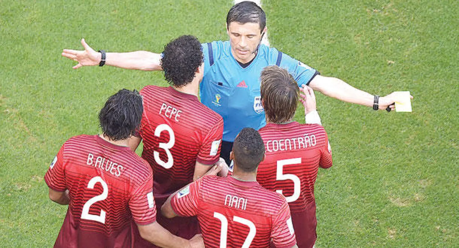 لاعبو البرتغال يعترضون على حكم المباراة بعد احتسابة ركلة جزاء لألمانيا (أ.ف.ب)