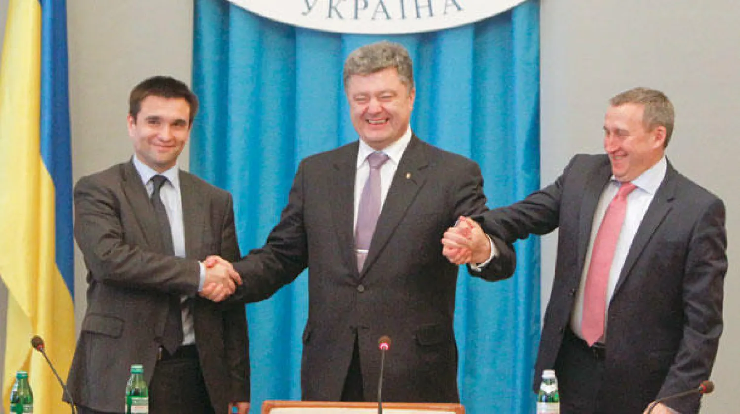 الرئيس بوروشينكو (وسط) يصافح وزير الخارجية الجديد بافلو كليمكين (يسار) وسلفه خاندريي ديشتشيتسا أمام موظفي الخارجية بكييف أمس (رويترز)