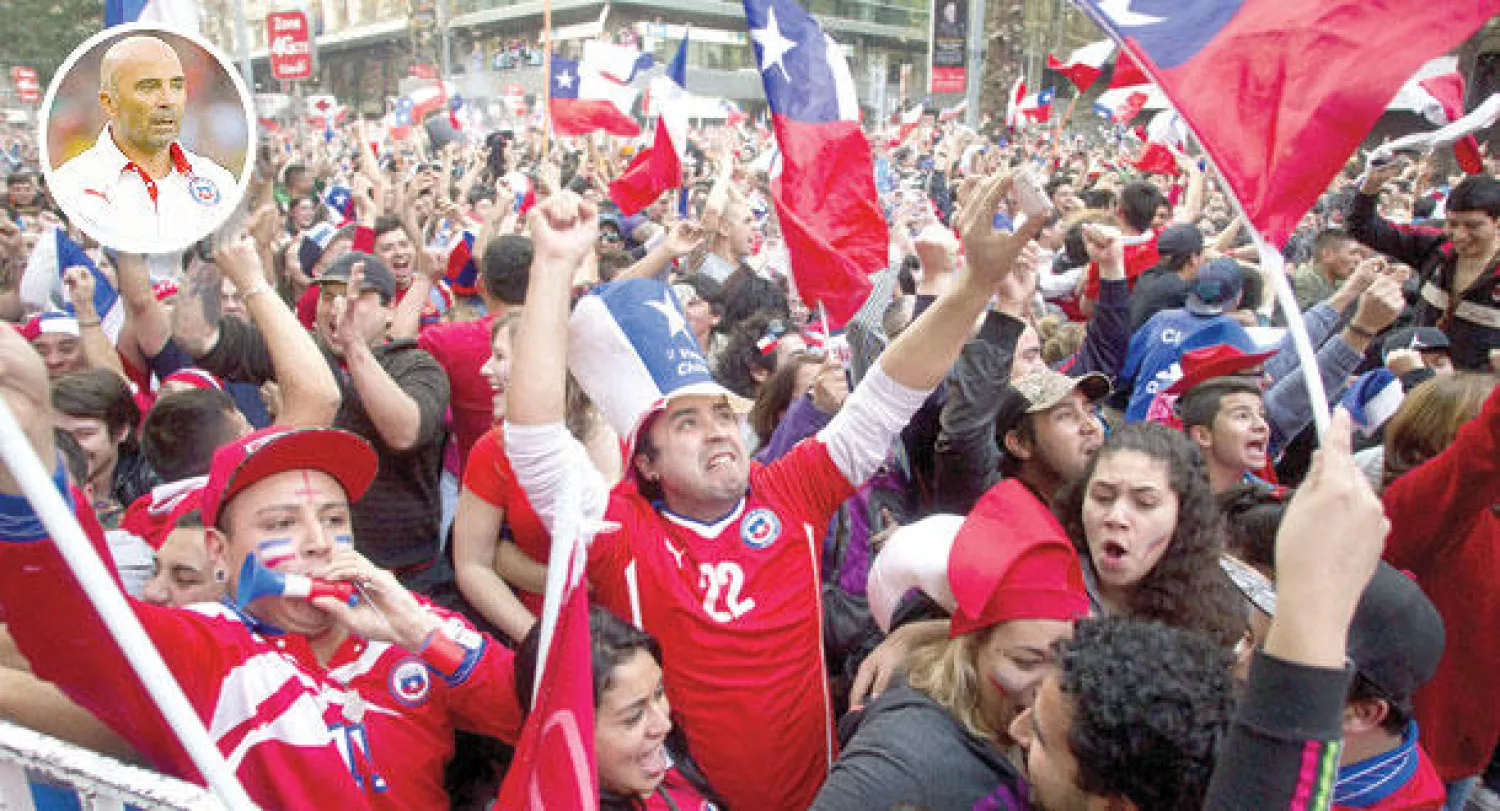 جماهير تشيلي خرجوا للاحتفال بانتصار منتخبهم على الإسبان (أ.ف.ب)  وفي الاطار سامباولي مدرب منتخب تشيلي
