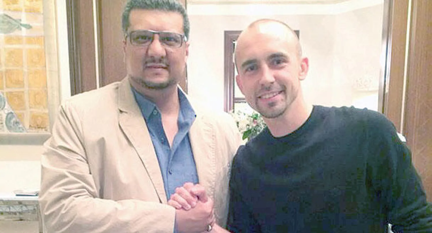 رئيس النصر وإلى جانبه البولندي أدريان بعد توقيع العقد