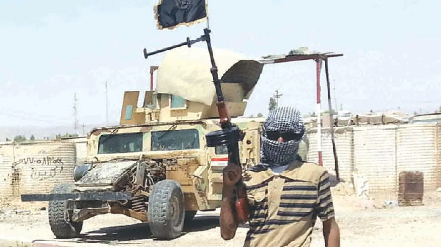 عنصر في تنظيم داعش عند نقطة تفتيش في بيجي إلى الشمال من بغداد (رويترز)