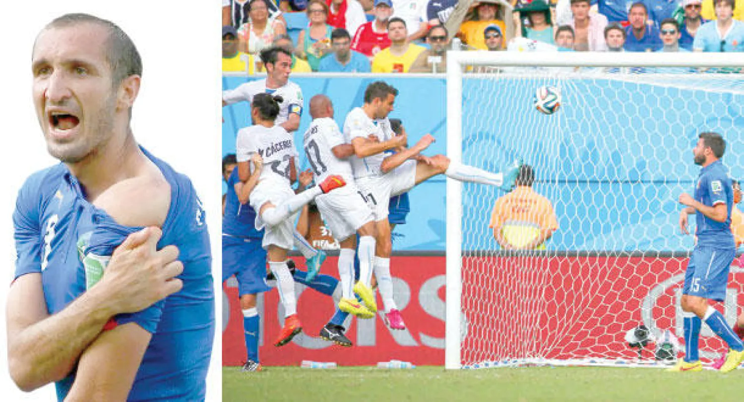 غودين (أقصى اليسار) يسدد برأسه ويحرز هدف الإطاحة بإيطاليا (رويترز)   -  مدافع إيطاليا  كييليني يكشف عن عضة سواريز (رويترز)