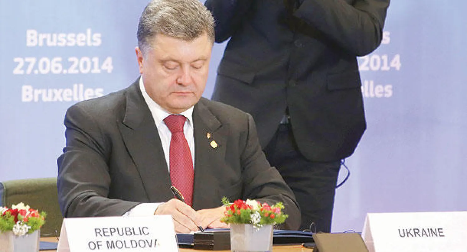 بوروشينكو أثناء توقيعه اتفاق الشراكة  مع الاتحاد الأوروبي في بروكسل أمس (رويترز)