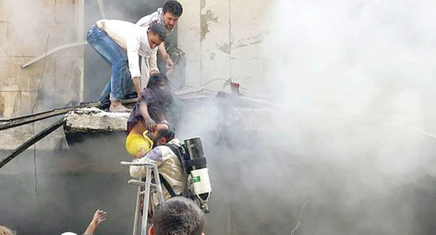 سوريون يحاولون انقاذ طفلة إثر غارة لطيران النظام على منطقة كرم الجبل في حلب أمس (أ.ب)