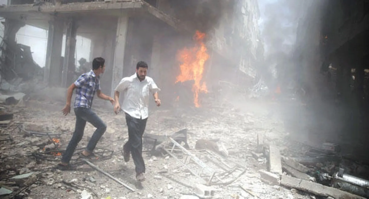 سوريون يفرون من مبنى تعرض لتفجير في منطقة الدوما بشرق الغوطة بالقرب من العاصمة دمشق أمس (رويترز)