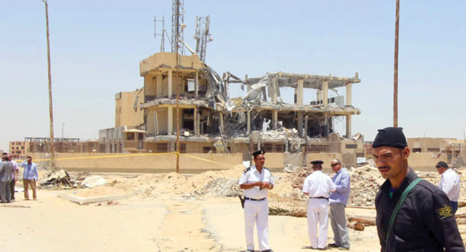 رجال أمن يتفقدون موقع الانفجار في مركز للاتصالات الهاتفية والأضرار الناتجة عنه (رويترز)