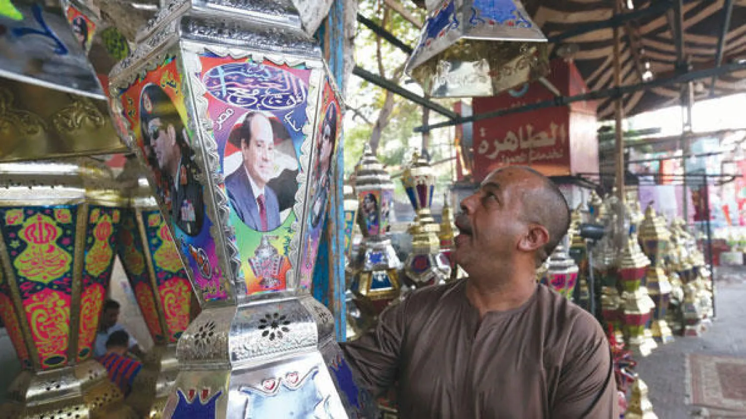 صورة الرئيس عبد الفتاح السيسي تزين واجهة فوانيس رمضان بأحد الأسواق القديمة في القاهرة أمس (رويترز)