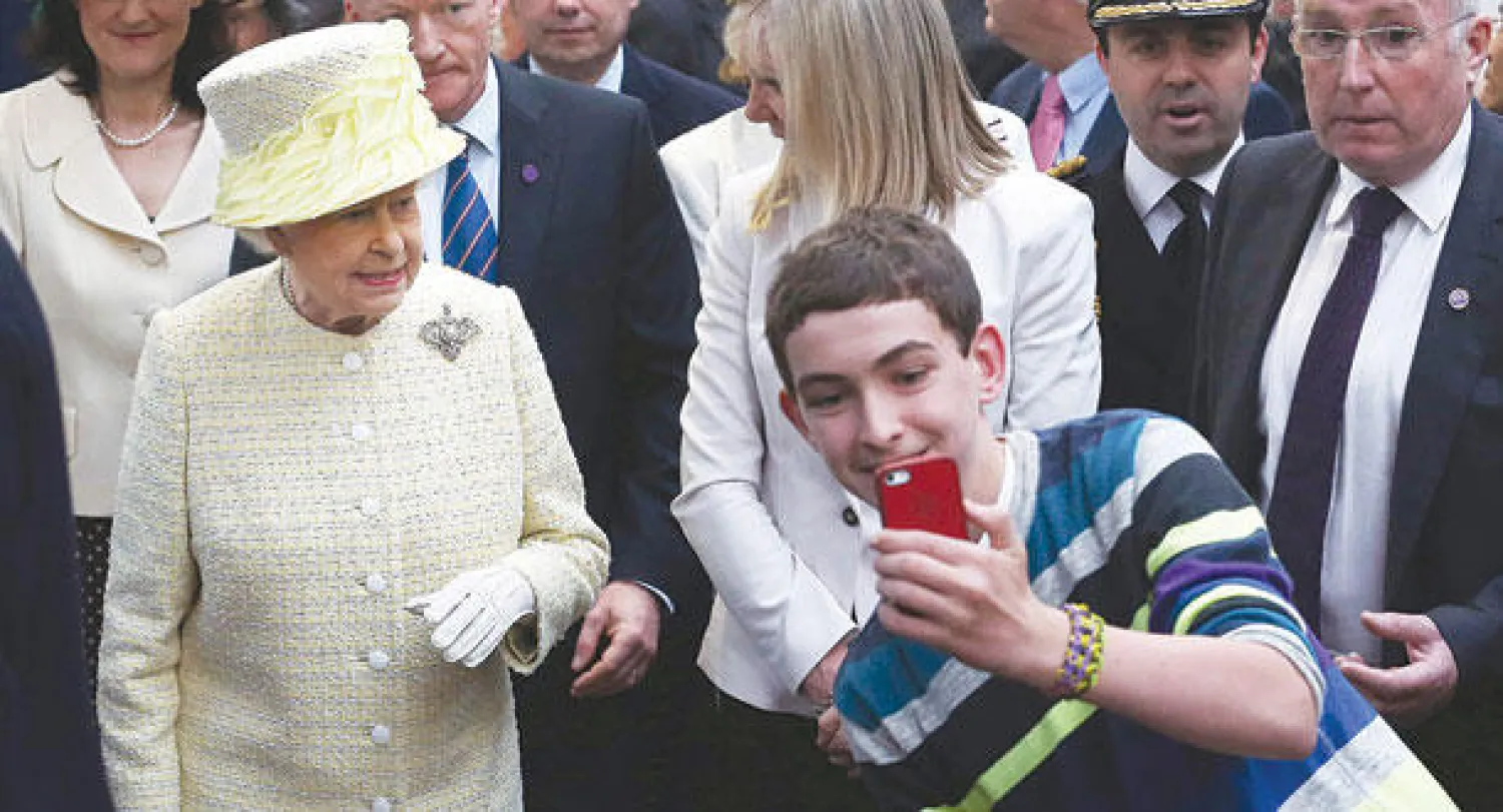 صبي يلتقط صورة «سلفي» مع الملكة إليزابيث (رويترز)