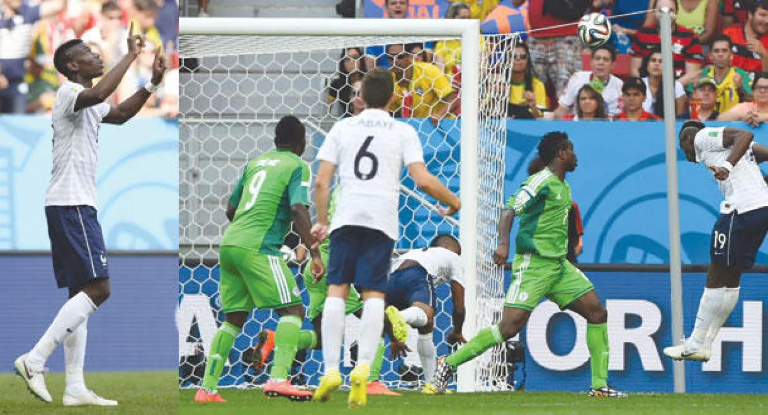 بوغبا نجم فرنسا (يمين) يسدد برأسه نحو مرمى نيجيريا مسجلا هدف منتخب بلاده الأول (رويترز)  -  الفرنسي بوغبا يحتفل بهدفه (أ.ف.ب)