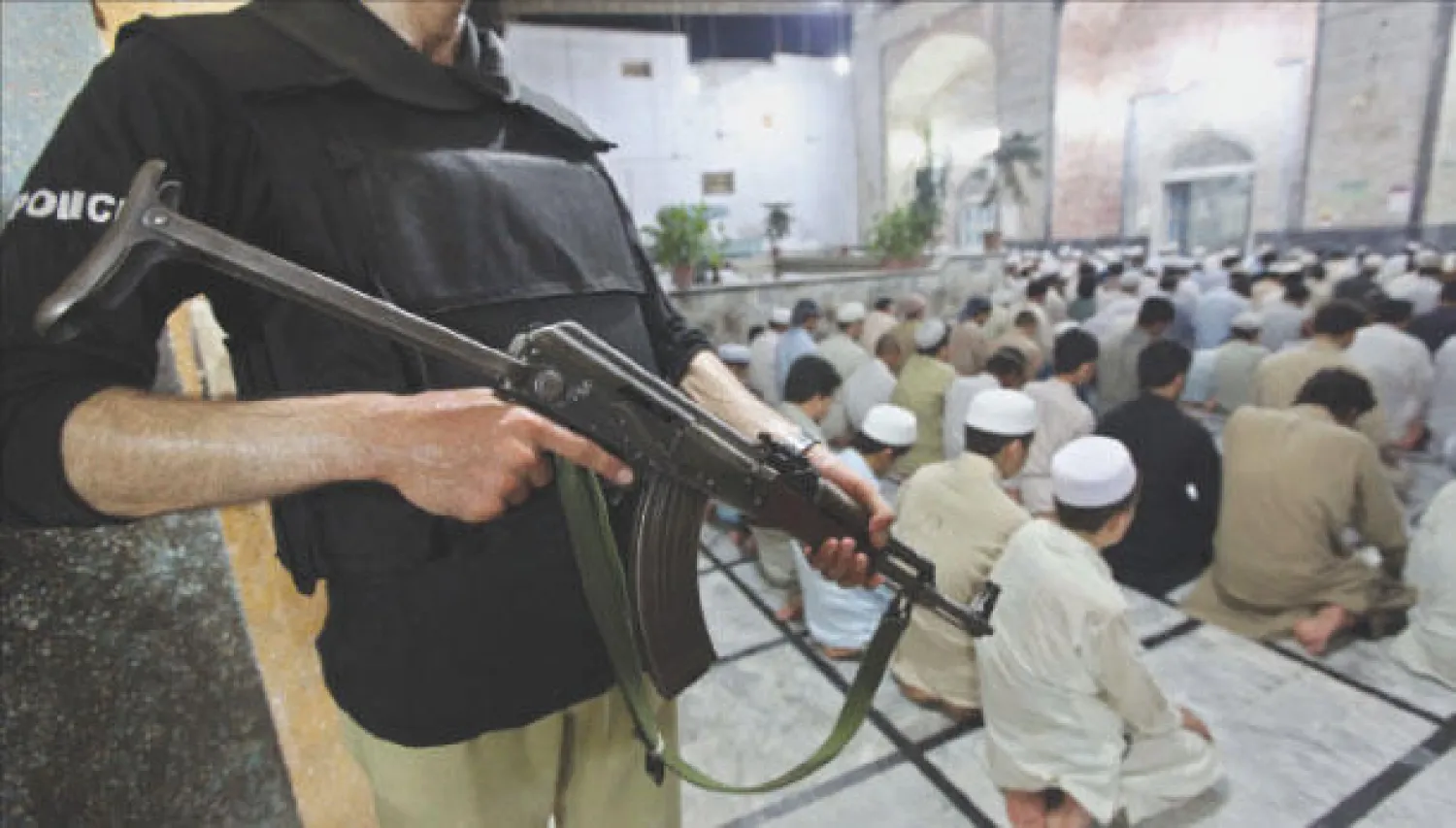 مسلمون باكستانيون يؤدون صلاة التراويح في بيشاور بالقرب من الشريط القبلي وسط حراسة أمنية مشددة (إ.ب.أ)