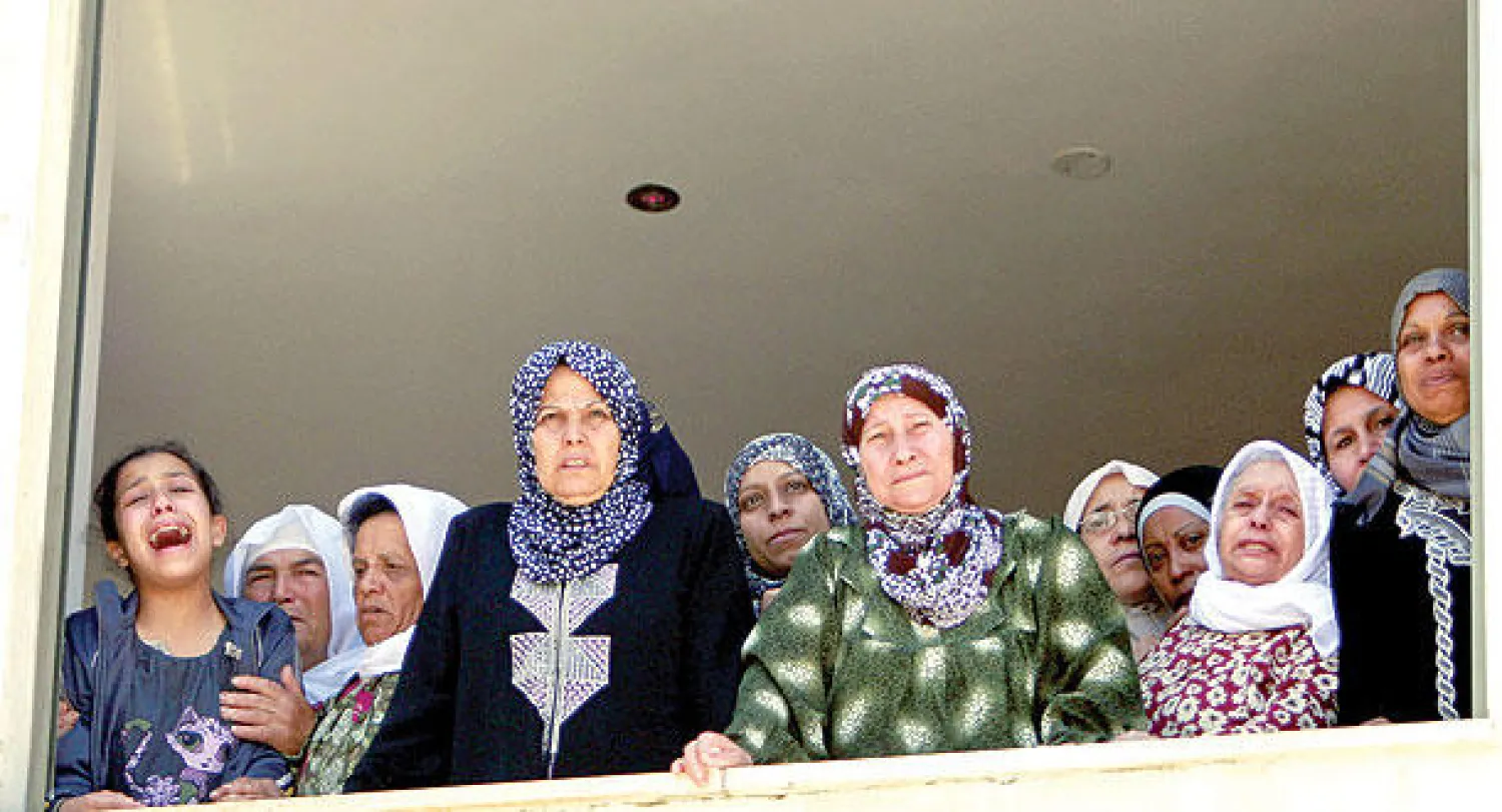 قريبات فلسطيني لقي حتفه على يد الجيش الإسرائيلي  ينتحبن خلال تشييعه بمخيم جنين بالضفة الغربية أمس (أ.ب)