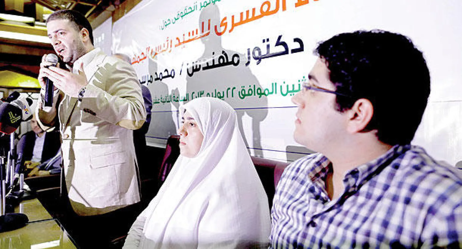 صورة أرشيفية لأبناء الرئيس المصري المعزول محمد مرسي أثناء مؤتمر صحافي السنة الماضية (أ.ب)