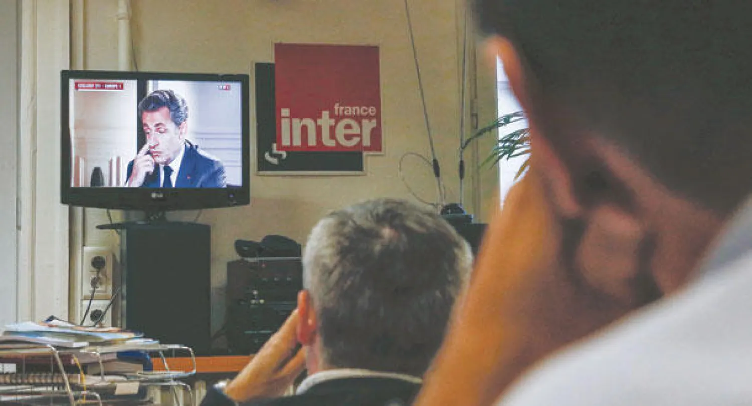 مسؤولون محليون في حزب «الاتحاد من أجل حركة شعبية» بمدينة ليون يشاهدون التسجيل التلفزيوني لساركوزي مساء أول من أمس (رويترز)