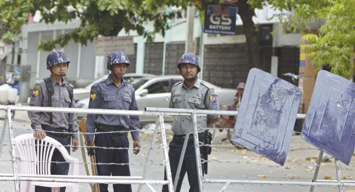 عسكريون يقفون أمام نقطة تفتيش في مدينة ماندلاي التي تشهد تجددا للعنف الطائفي أمس (إ.ب.أ)