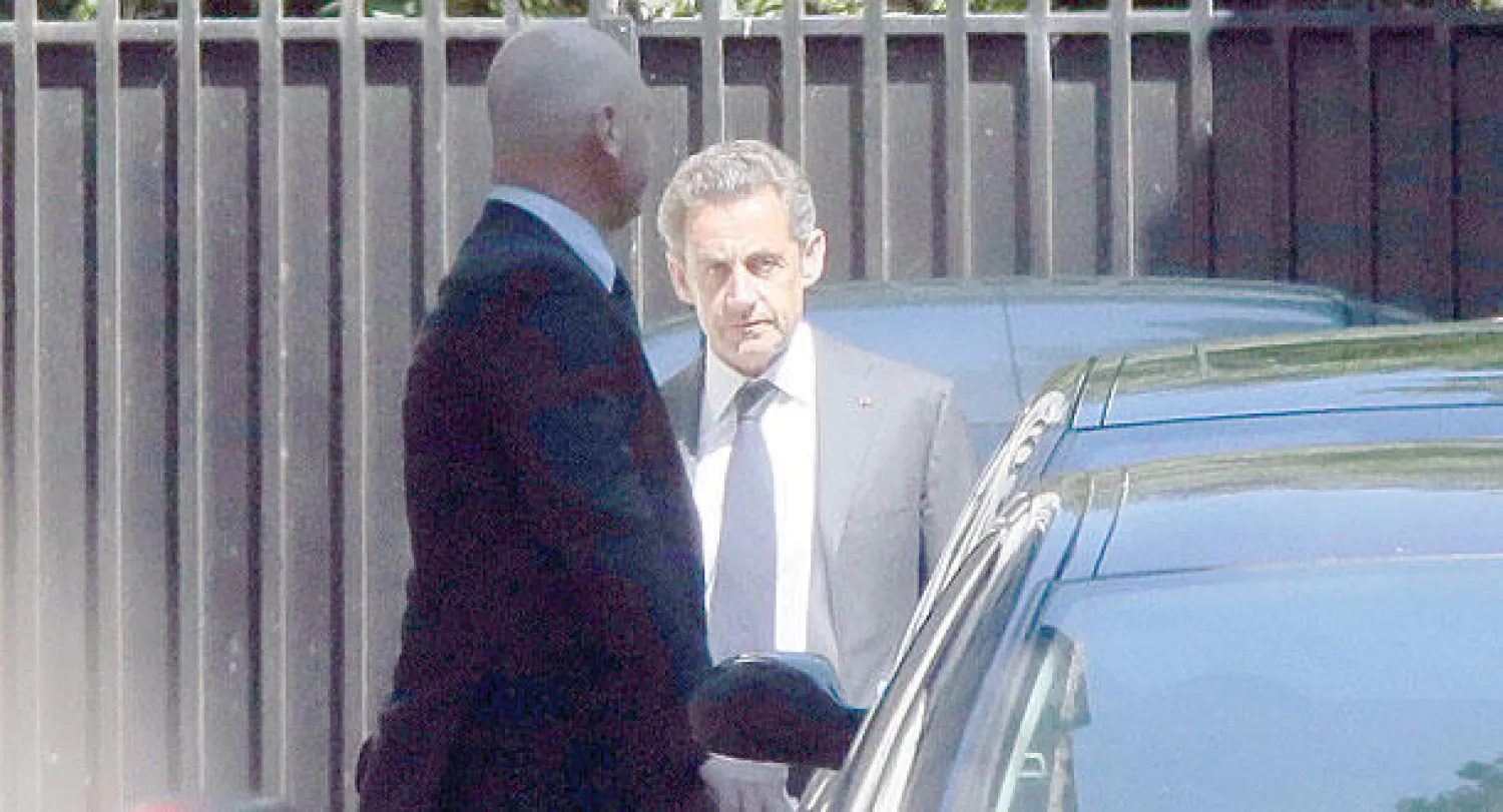 ساركوزي أثناء مغادرته منزله في باريس أمس (أ.ف.ب)