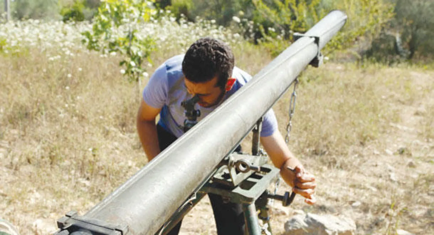 مقاتل من المعارضة السورية يوجه صاروخا لإطلاقه نحو القوات النظامية في ريف اللاذقية أمس (رويترز)