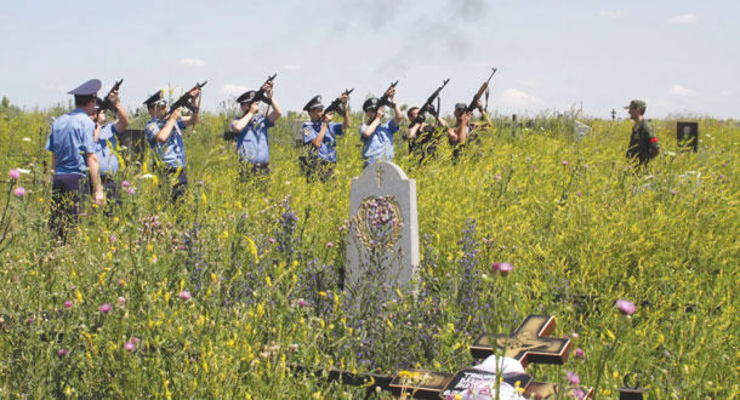 رجال شرطة أوكرانيون يطلقون النار في الهواء خلال جنازة ثلاثة من رفاقهم قتلهم مسلحون مجهولون في دونيتسك بشرق البلاد أمس (ا.ب.ا)