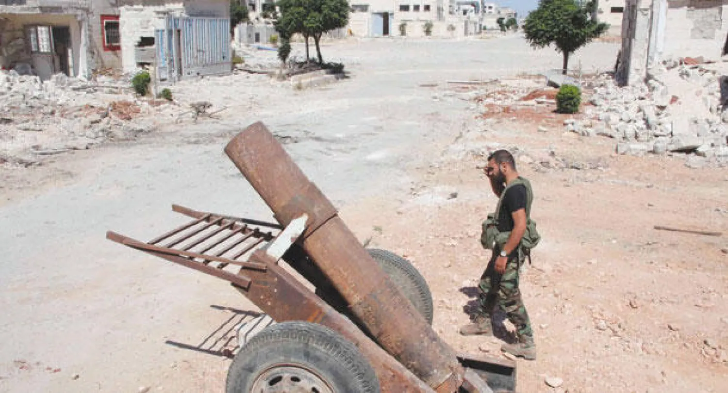 جندي من القوات النظامية السورية قرب مدفع تركه معارضون بعد السيطرة على المدينة الصناعية في حلب