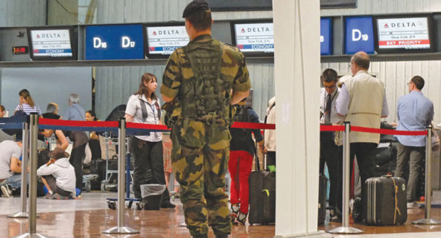 جندي يقف أمام مكتب لشركة «دلتا إيرلاينز» الأميركية في مطار نيس بجنوب شرق فرنسا أمس (أ.ب)
