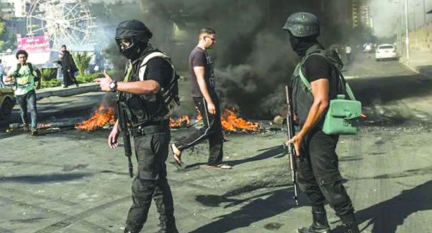 شرطيان خلال التدخل لإنهاء أعمال شغب لأنصار الرئيس السابق مرسي أمس بالقاهرة