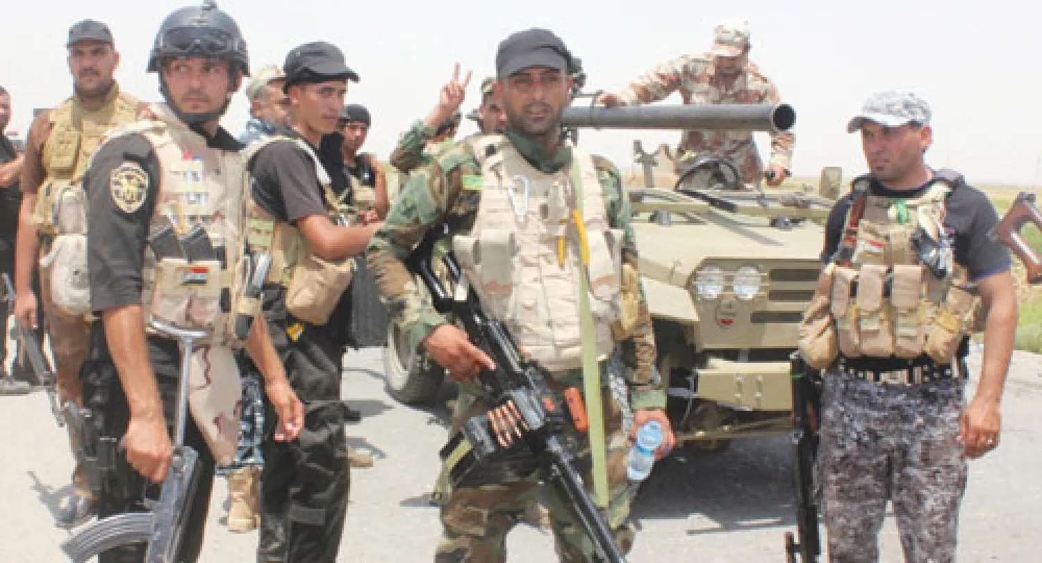 عربة مدرعة تابعة للجيش العراقي معلقة وسط مياه النهر قرب مدينة ديالى، شرق بغداد، التي تدور فيها مواجهات بين مسلحين والقوات الحكومية (رويترز)