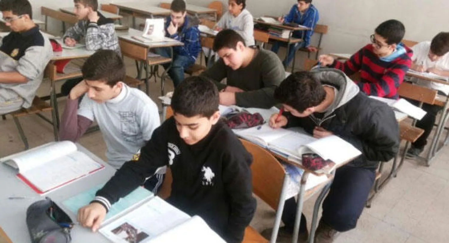 طلاب يطالعون كتاب اللغة العربية في إحدى المدارس الرسمية («الشرق الأوسط»)