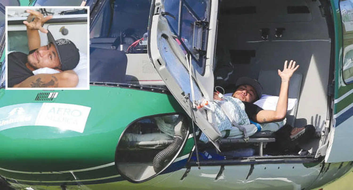 نيمار يلوح بيده خلال مغادرته مقر المنتخب البرازيلي في مروحية (إ.ب.أ)