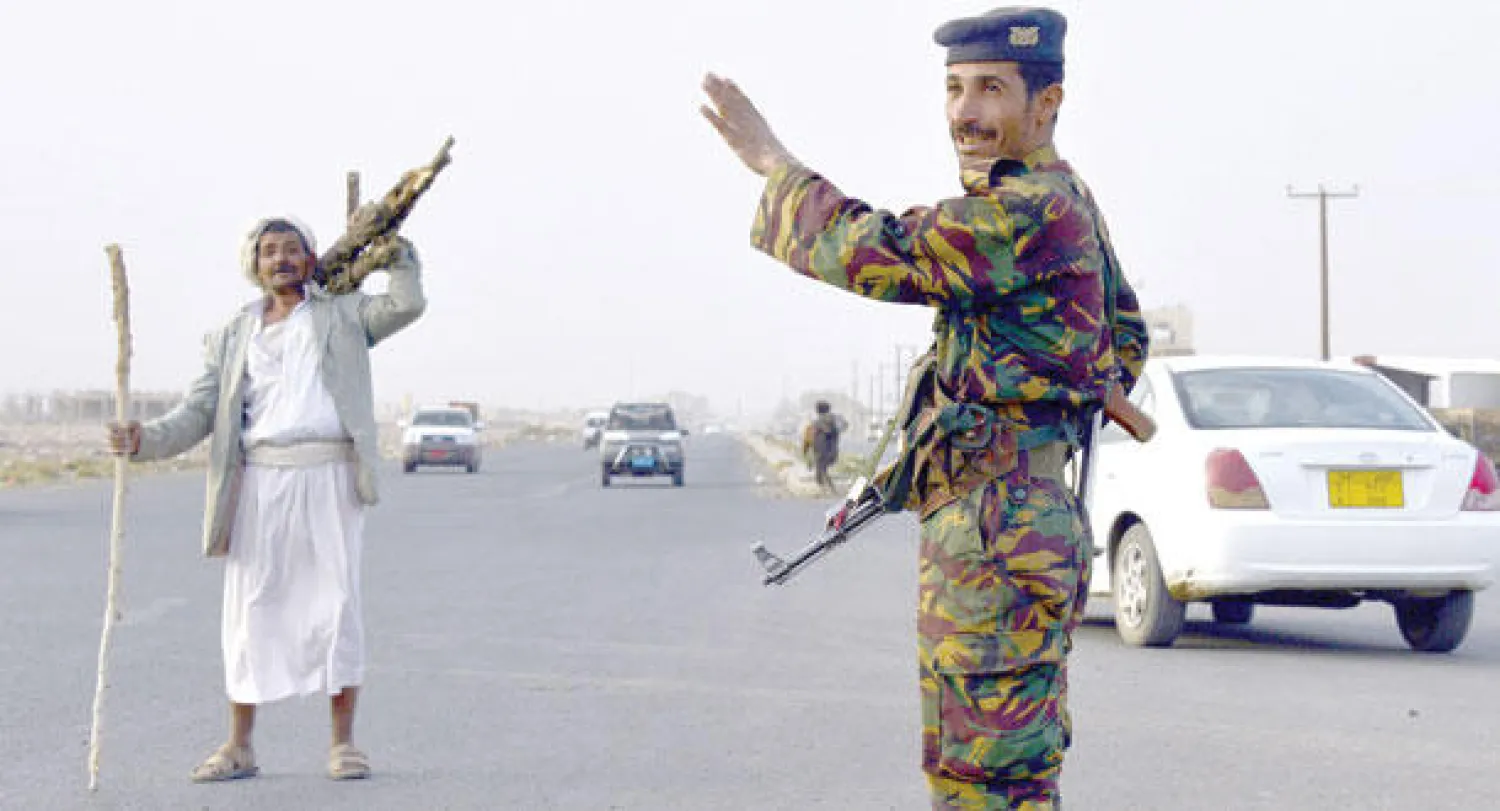 جندي يمني عند نقطة تفتيش على الطريق بين صنعاء وعمران أمس (أ.ف.ب)