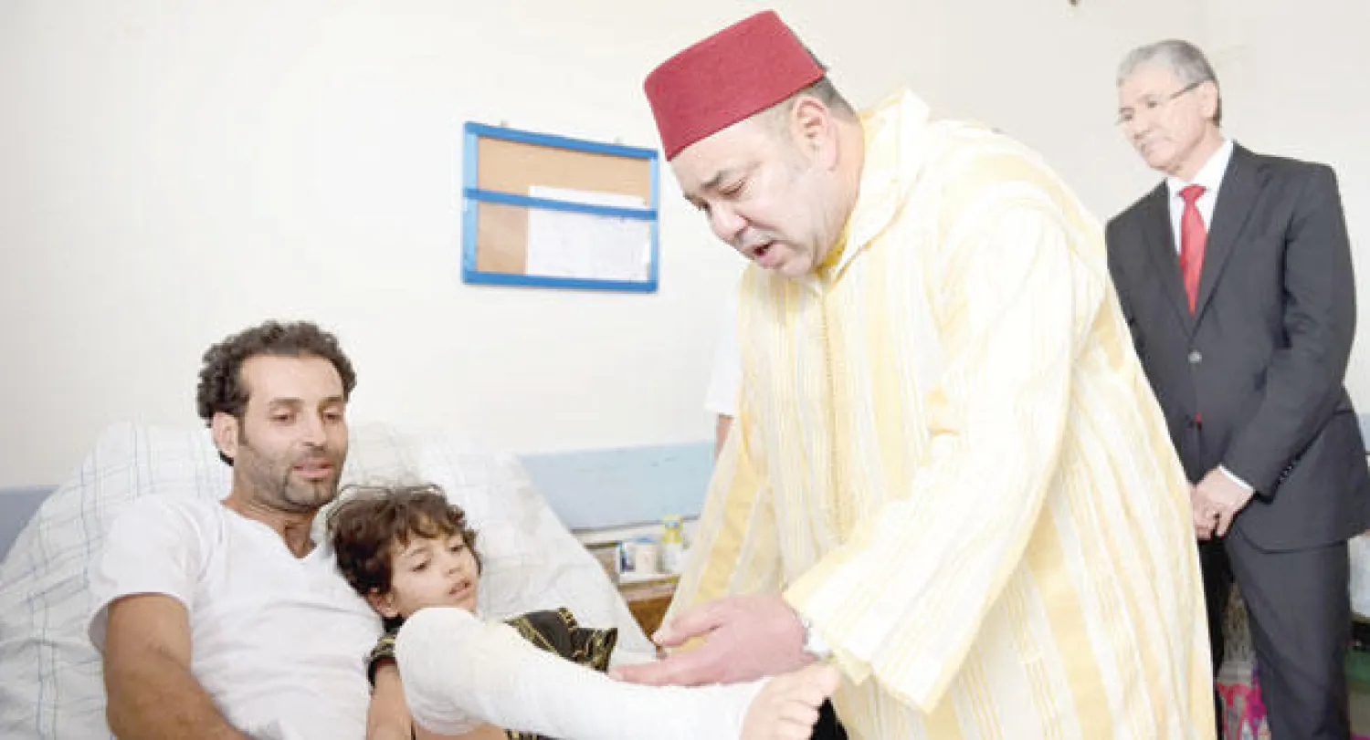 الملك محمد السادس يزور أحد الناجين أمس (ماب)