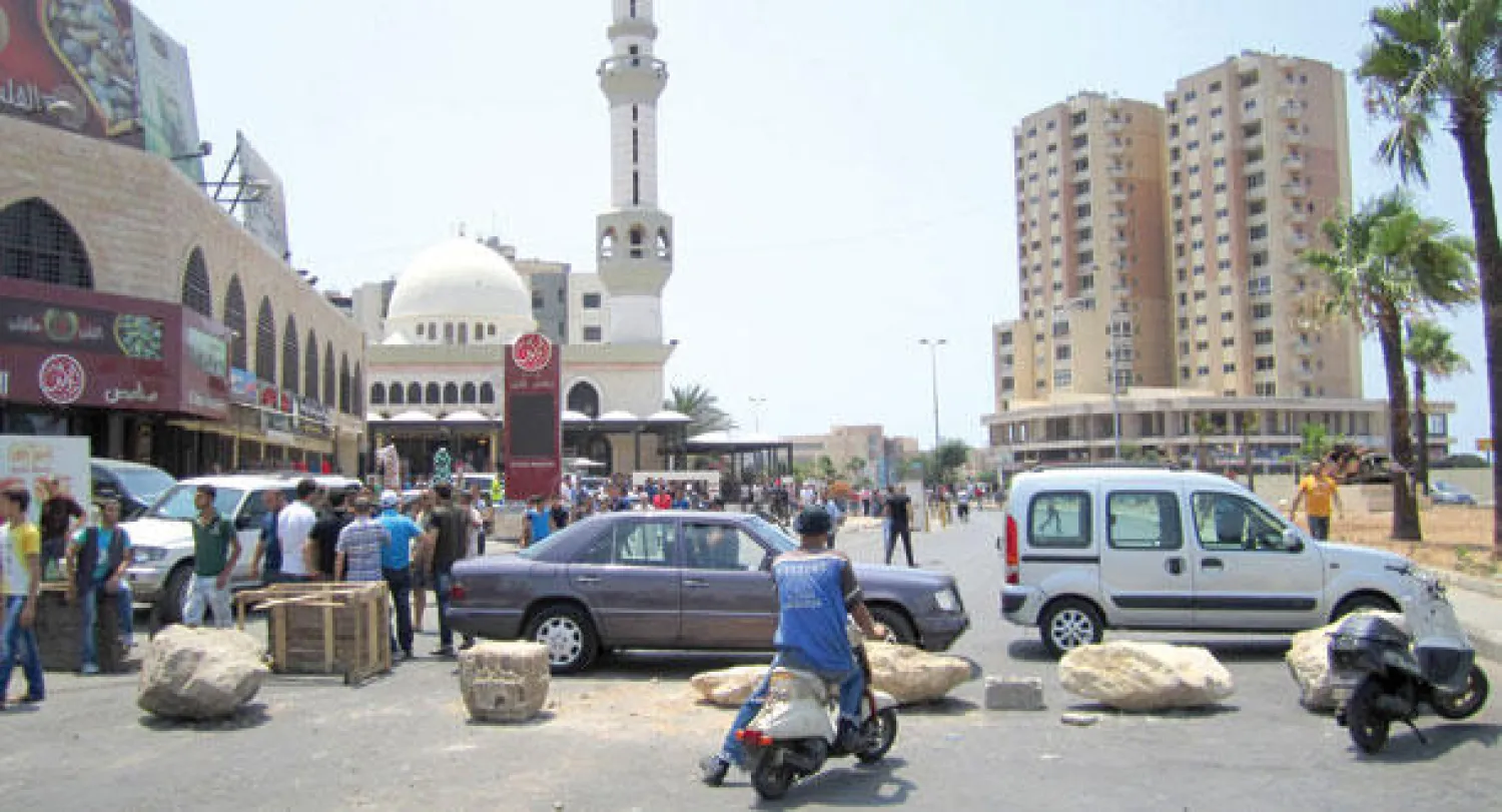 الحاجز الذي وضعه المعتصمون بالحجارة في أحد شوارع طرابلس (رويترز)