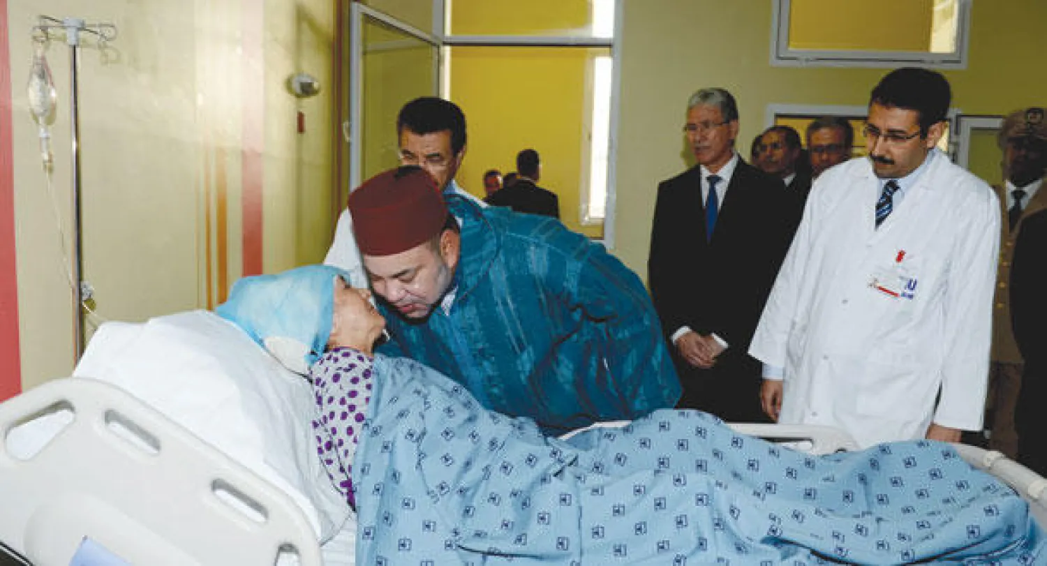 الملك محمد السادس لدى زيارته للمرة الثانية ضحايا العمارة المنهارة في الدار البيضاء مساء أول من أمس (ماب)