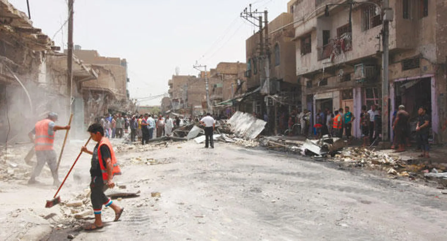 عمال البلدية يزيلون الأنقاض التي خلفها تفجير في منطقة العلوية ببغداد أمس (أ.ب)