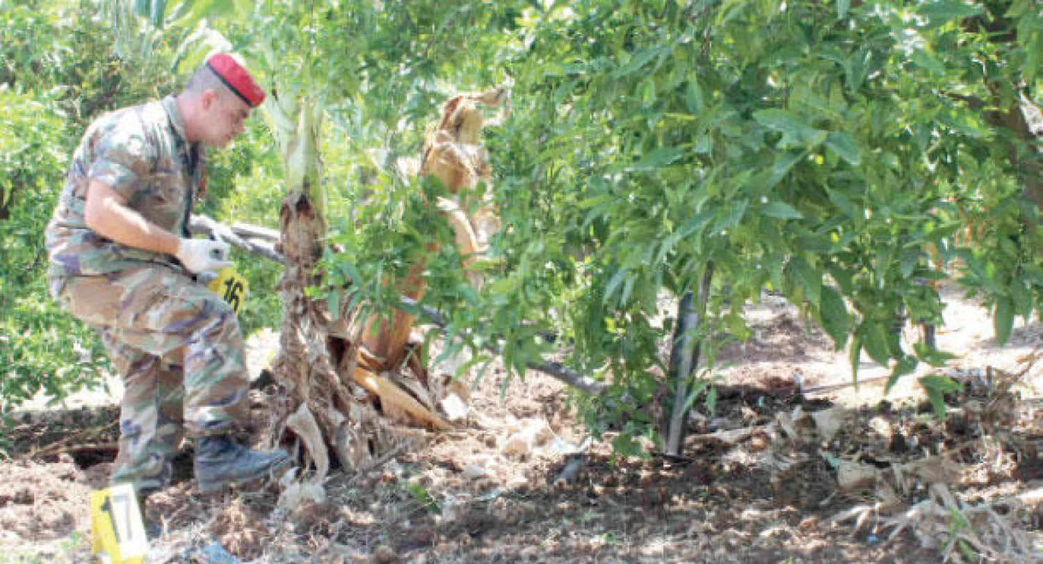 أحد عناصر الجيش اللبناني يتفقد موقعا في جنوب لبنان قصفته إسرائيل بصاروخ أول من أمس (رويترز)