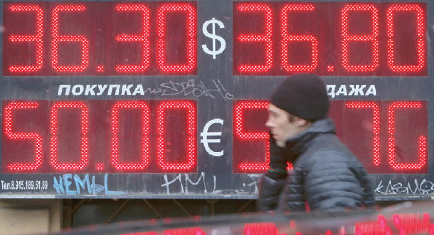 رجل يمر أمام محل للصيرفة في موسكو (رويترز)