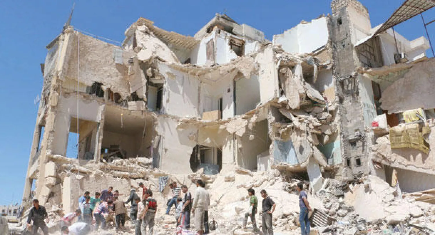 عمال إنقاذ يبحثون عن ناجين بين ركام بنايات قصفتها القوات النظامية شمال حلب أمس (أ.ف.ب)