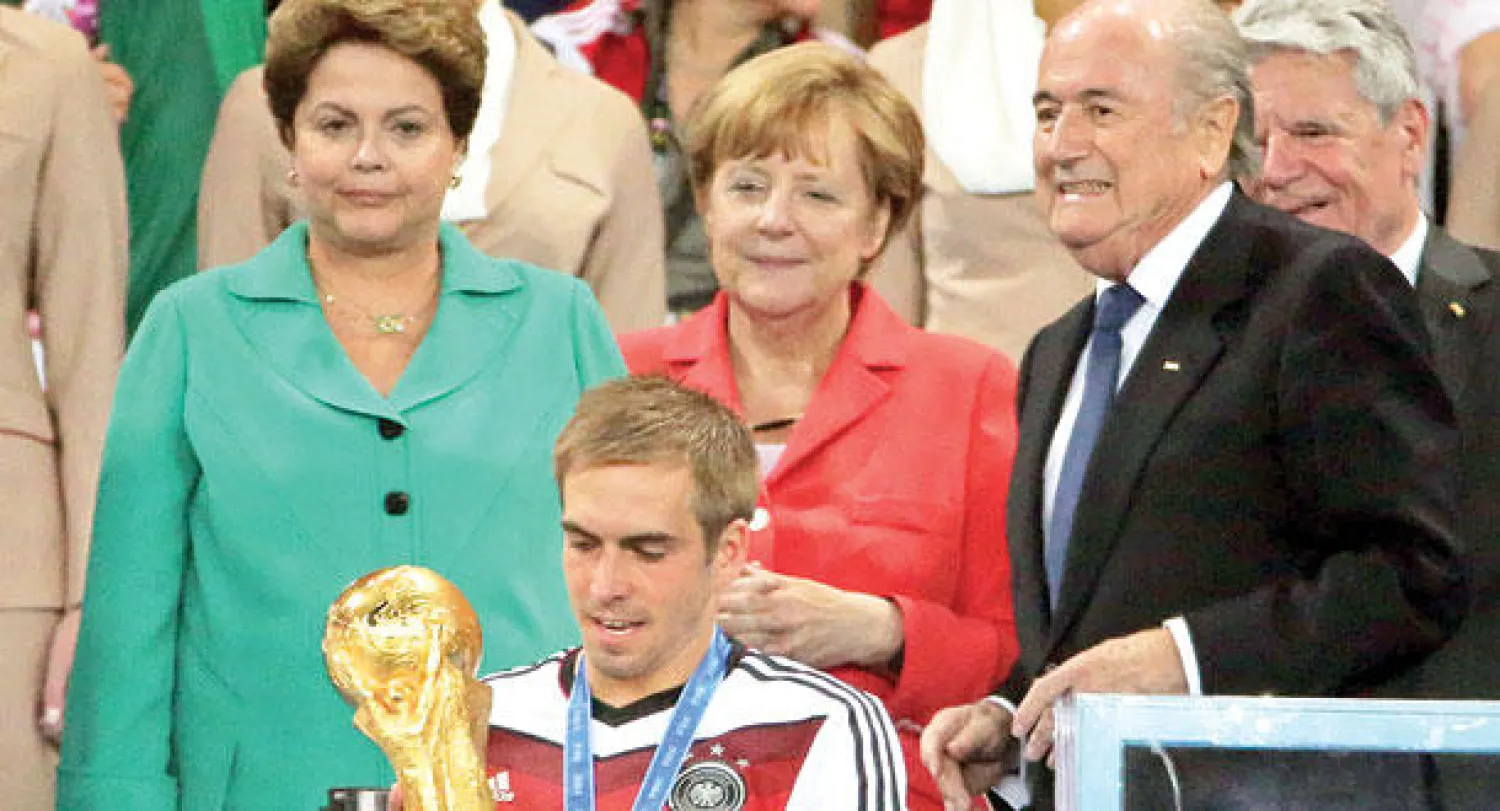 لام مع كأس العالم وخلفه من اليسار الرئيسة البرازيلية  والمستشارة الألمانية ورئيس الفيفا (إ.ب.أ)