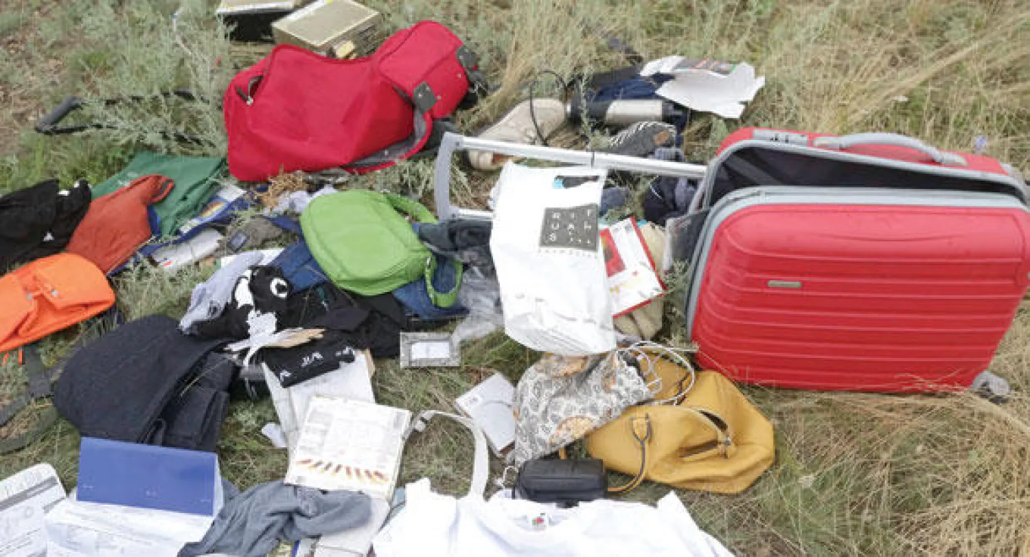 حقائب وأغراض شخصية عثر عليها في موقع تحطم الطائرة في حقل قمح بدونيتسك أمس (إ.ب.أ)
