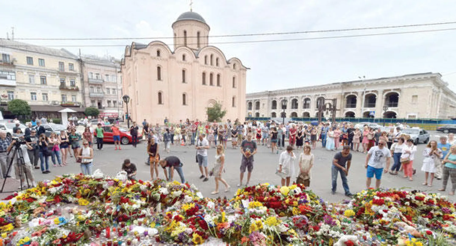 أوكرانيون يضعون وردا أمام السفارة الهولندية في كييف أمس لتذكر ضحايا الطائرة المنكوبة الذين مثل الهولنديون الغالبية بينهم (أ.ف.ب)