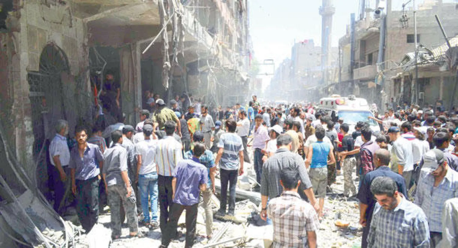 مواطنون سوريون متجمعون وسط مدينة دوما حيث انفجرت سيارة أمس (رويترز)