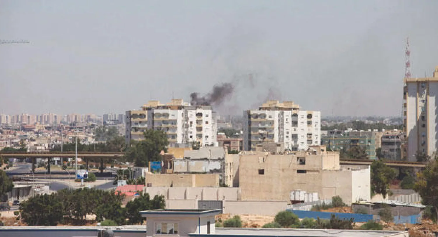 دخان يتصاعد من موقع اشتباكات بالقرب من مطار طرابلس أمس (ليبيا)