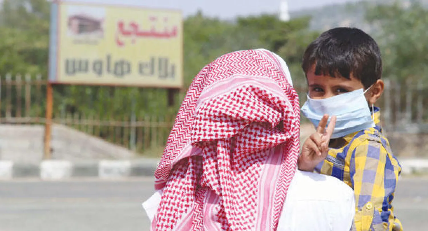 طفل سعودي ووالده لدى بداية التحذير باتخاذ الإجراءات الوقائية (رويترز)