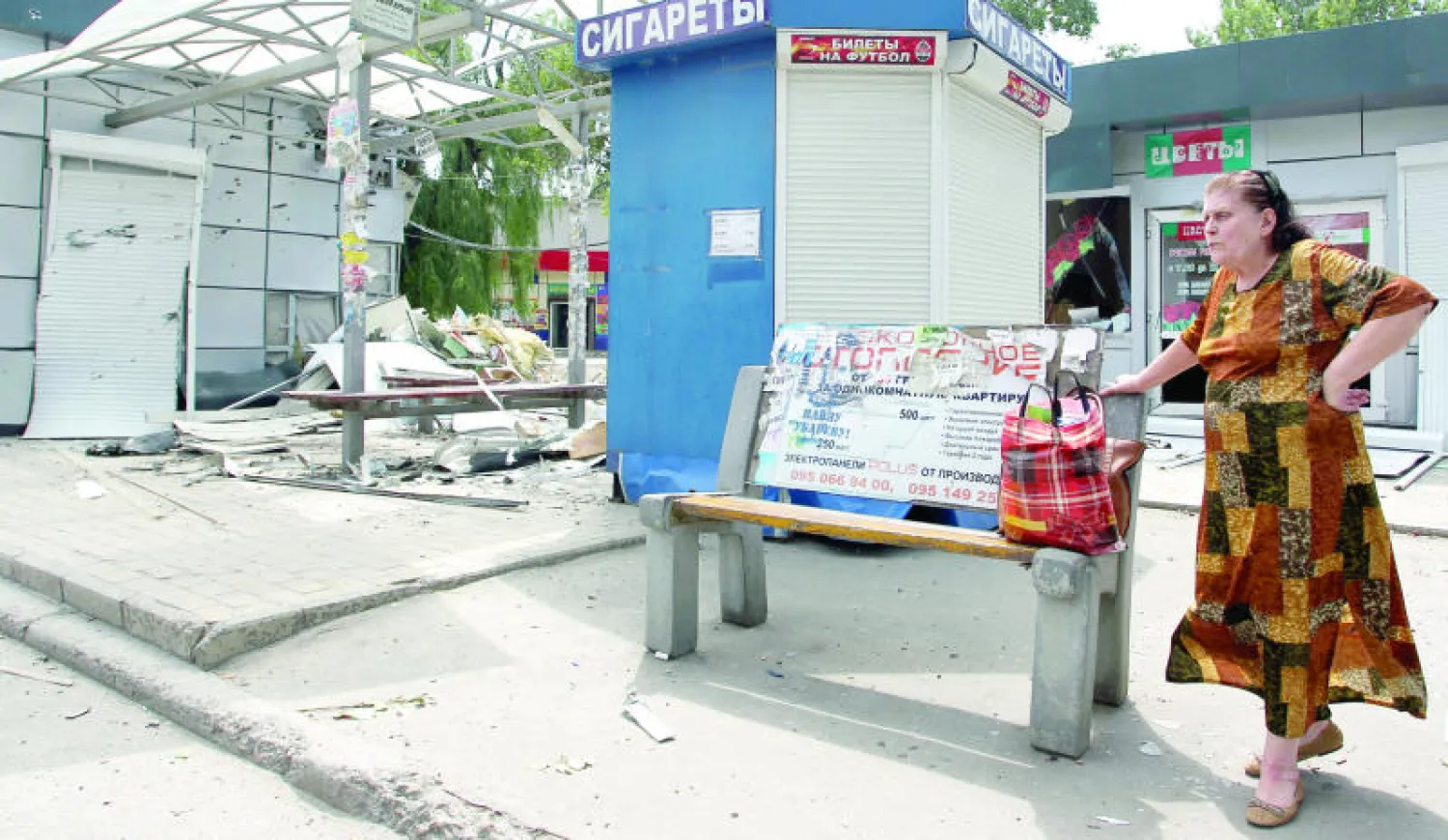 امرأة تنتظر أمام محطة حافلات دمرت بفعل المعارك في دونيتسك بشرق أوكرانيا أمس (إ.ب.أ)