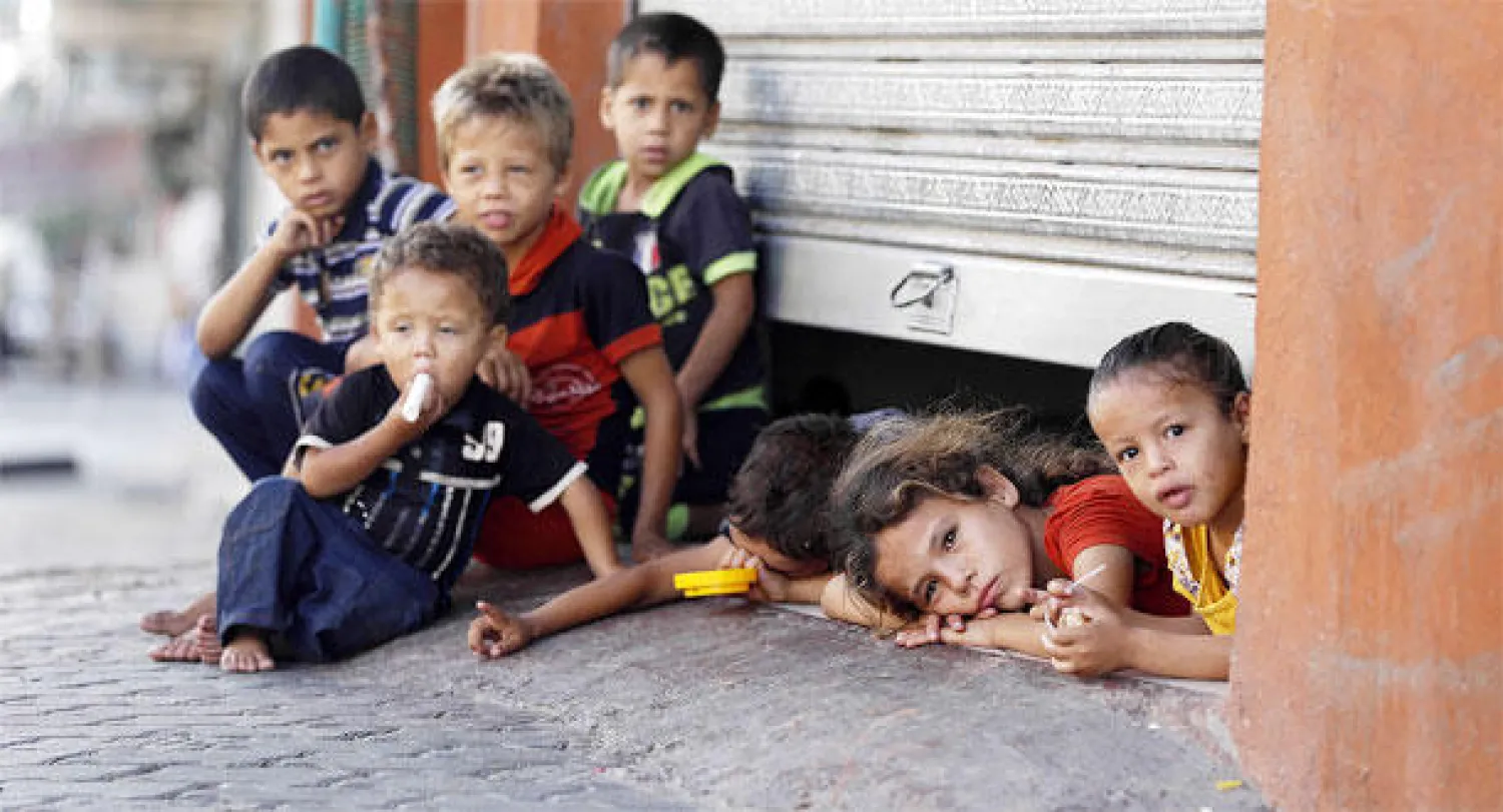 اطفال فلسطينيون مشردون داخل متجر هربا من القصف وخوفا من المصير المجهول (أ.ف.ب)
