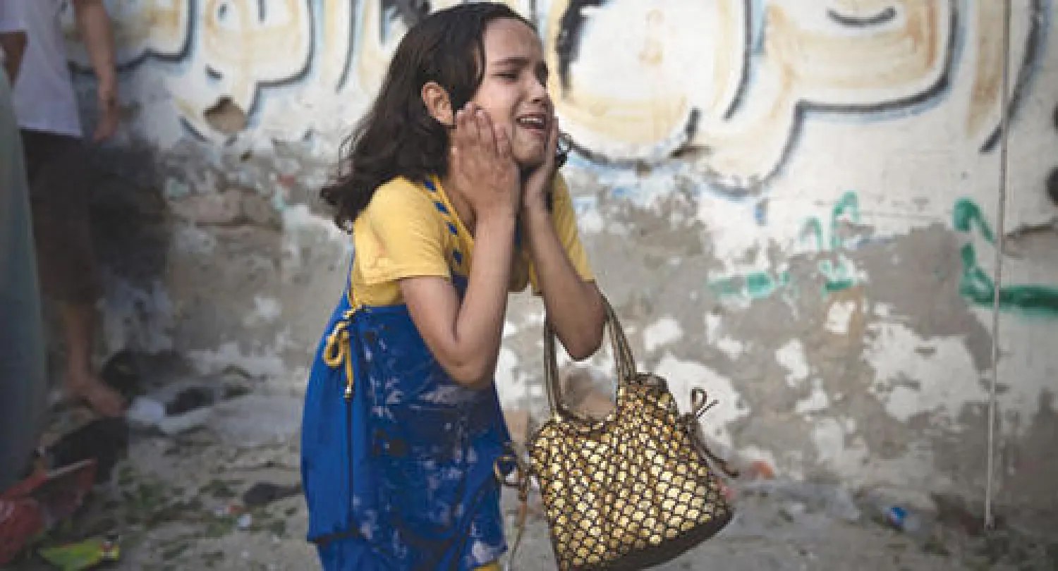 طفلة فلسطينية فزعة بعد أن نجت أمس من مجزرة في حديقة عامة بمدينة غزة قضى فيها عشرة أشخاص بينهم ثمانية أطفال (رويترز)