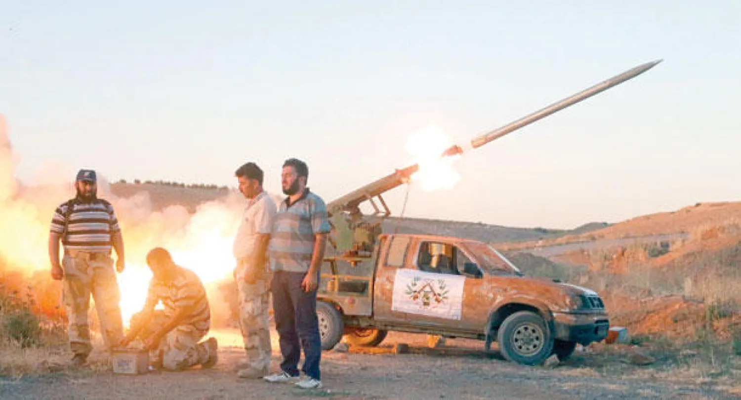 مقاتلو الجيش السوري الحر يطلقون صاروخا باتجاه المطار العسكري في حماة التي تسيطر عليها القوات الموالية للرئيس الأسد (أ.ف.ب)