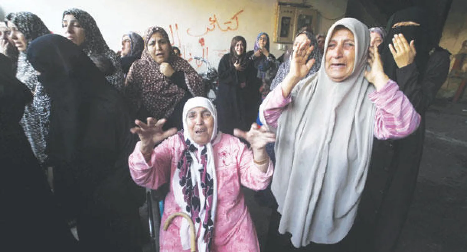 فلسطينيات ينتحبن بعد مقتل 10 من أفراد عائلة الغول في قصف إسرائيلي على رفح جنوب قطاع غزة أمس (أ.ف.ب)