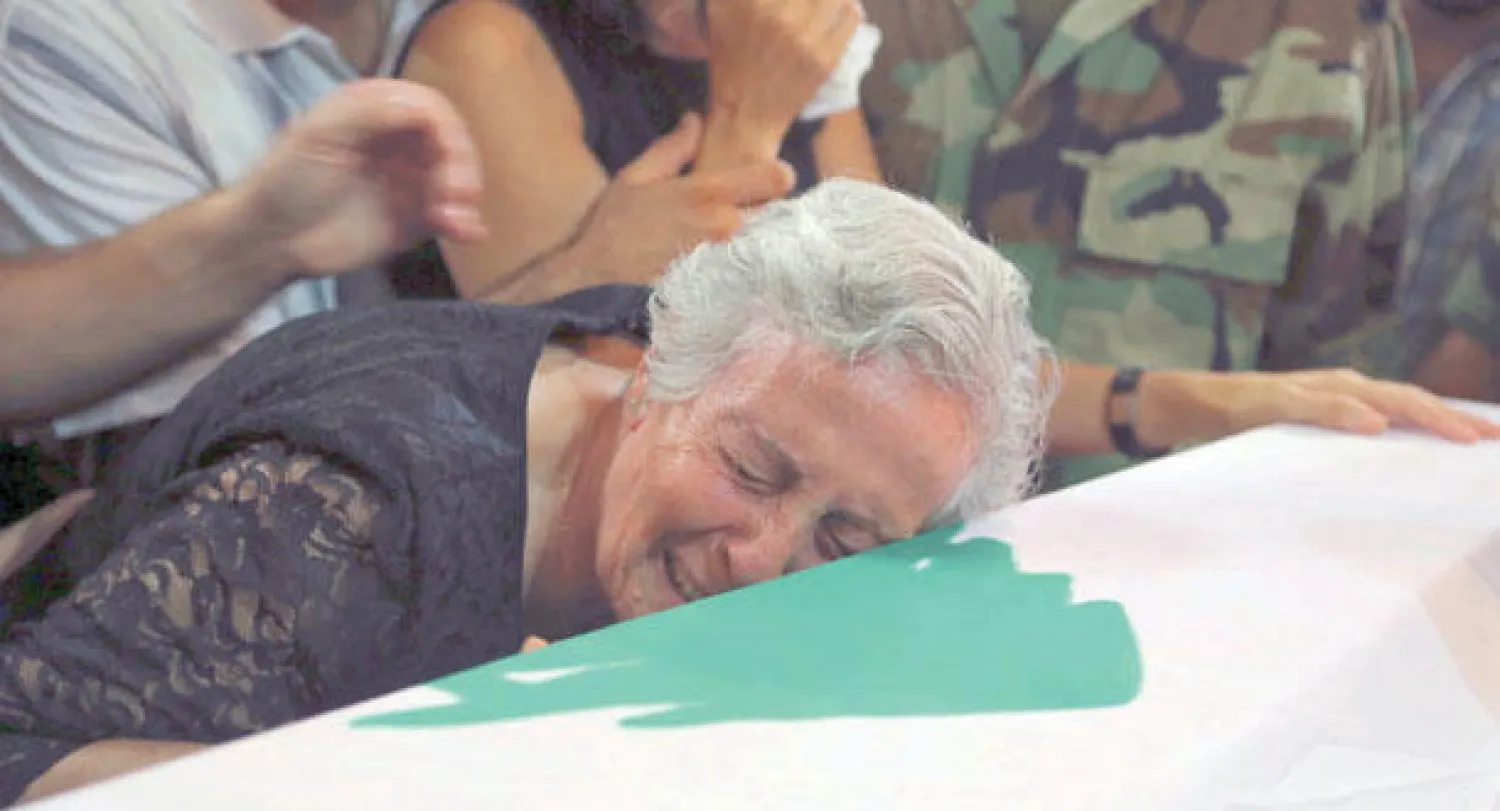 جدة المقدم في الجيش اللبناني داني حرب الذي قتل في معارك مع مسلحين في عرسال تبكي على نعشه خلال جنازته في بيروت أمس (رويترز)