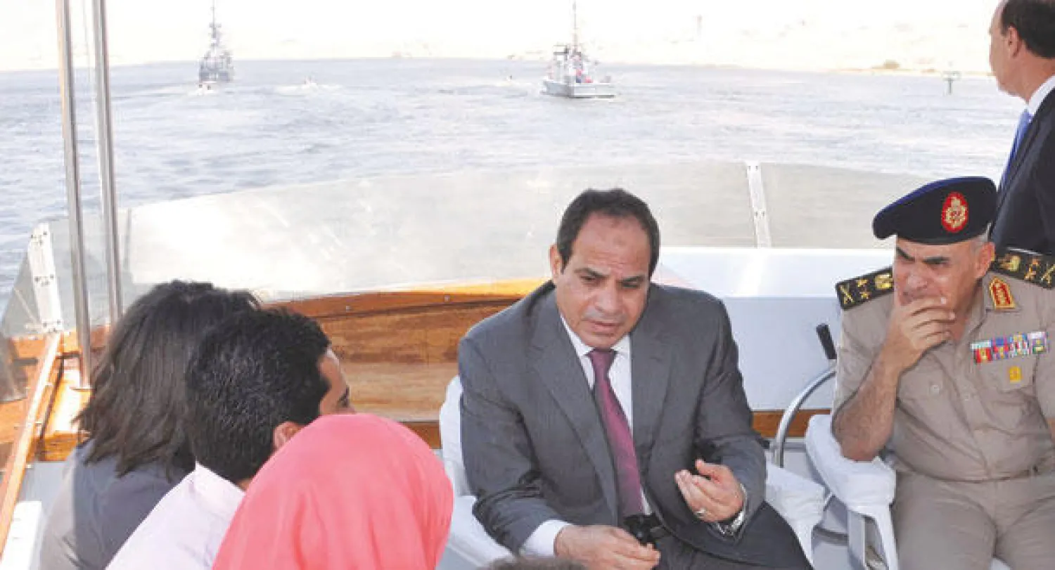 الرئيس السيسي يتحدث إلى مجموعة من الشباب في قارب بعد تدشينه مشروع تنمية محور قناة السويس الجديد يوم الثلاثاء الماضي (رويترز)
